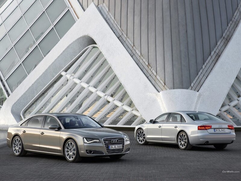 Audi A8 sedans in front of modern building