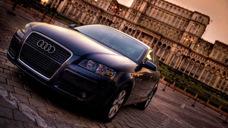 Audi car in front of a large building