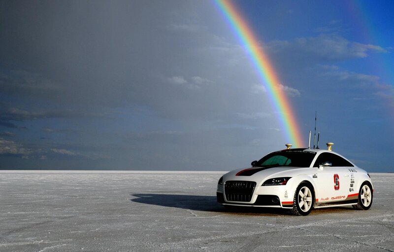 Audi car on salt flat with rainbow