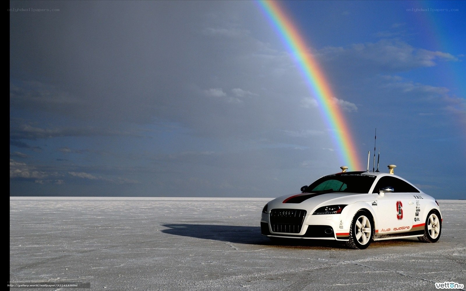 Audi car on salt flat with rainbow