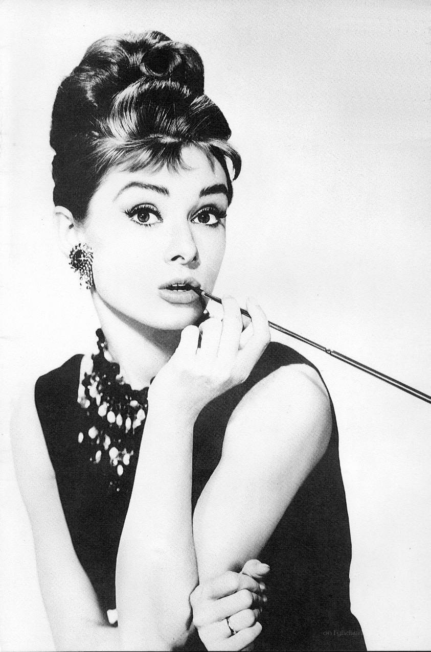 Audrey Hepburn applying lipstick