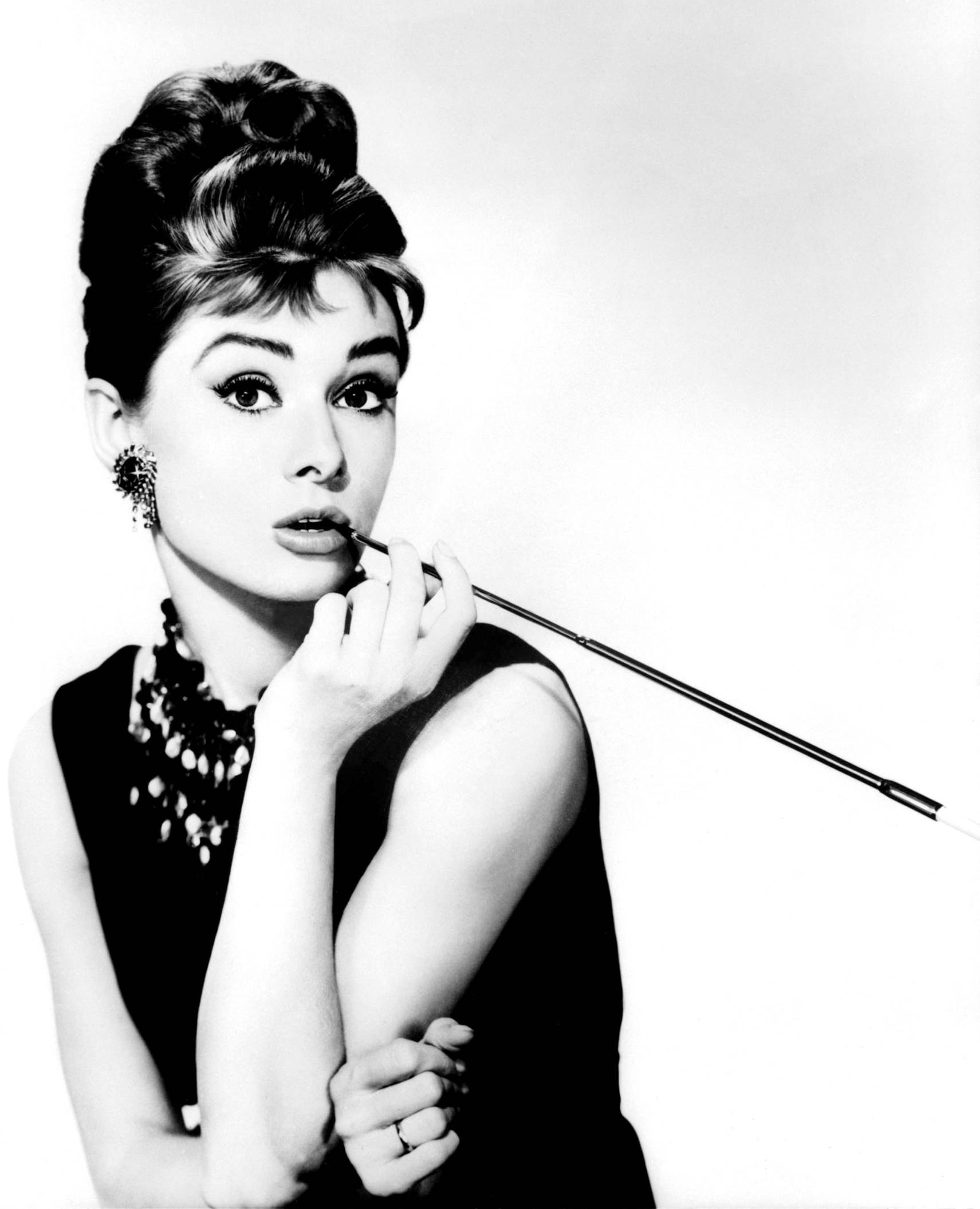 Audrey Hepburn applying lipstick