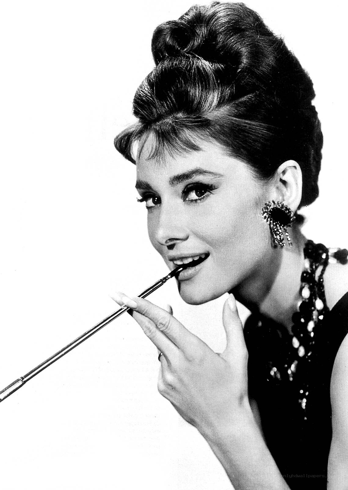 Audrey Hepburn applying lipstick