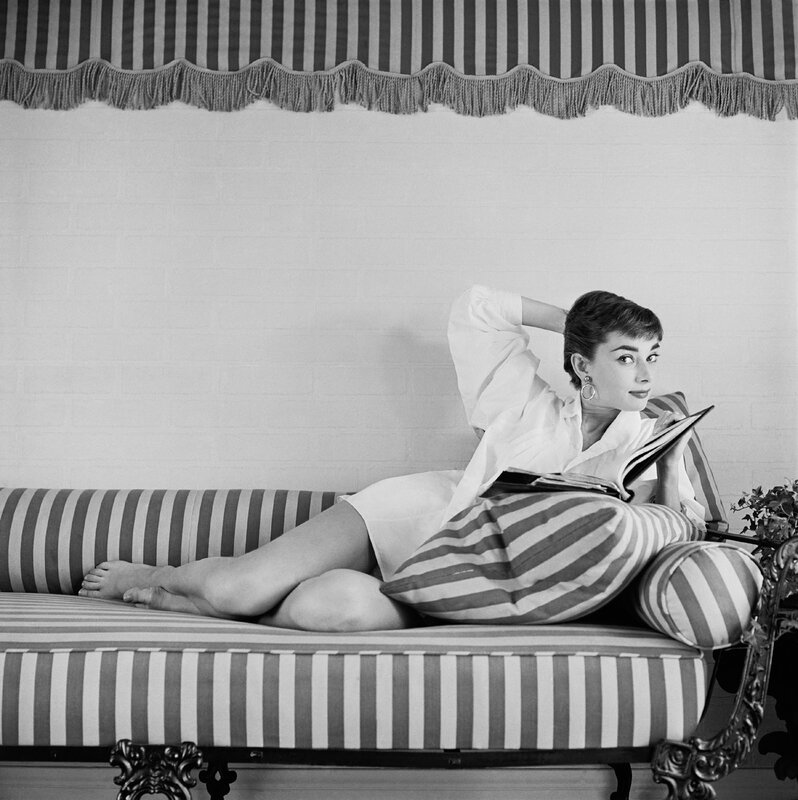 Audrey Hepburn reading on a chaise