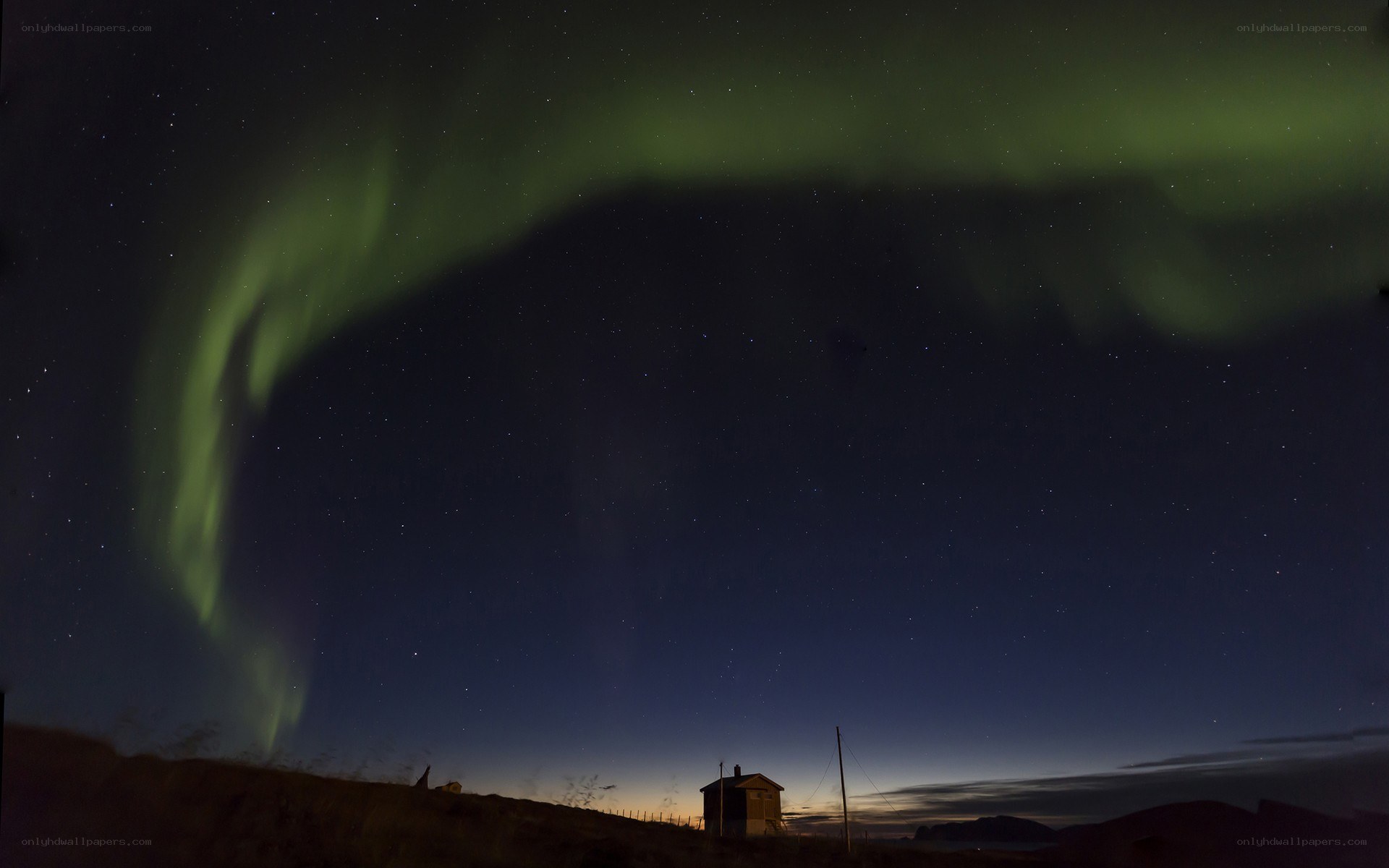 Aurora borealis over a cabin