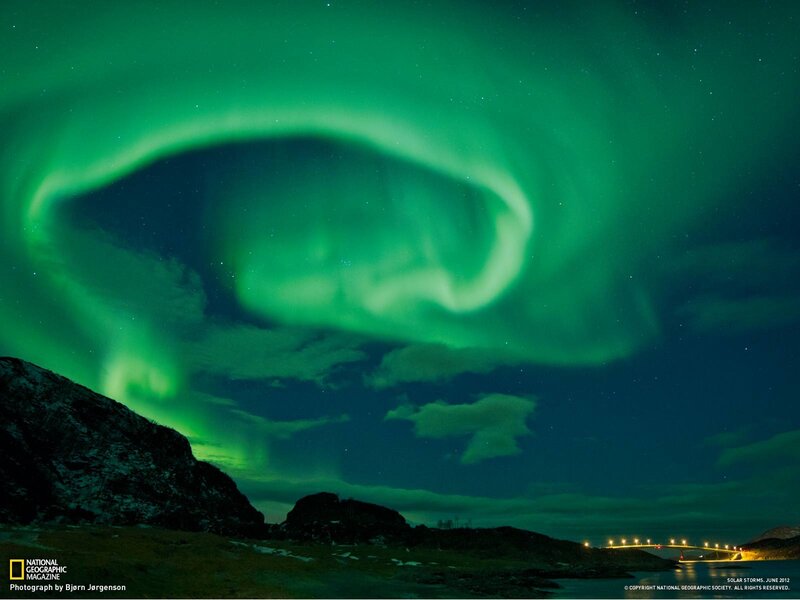 Aurora borealis over a coastal landscape