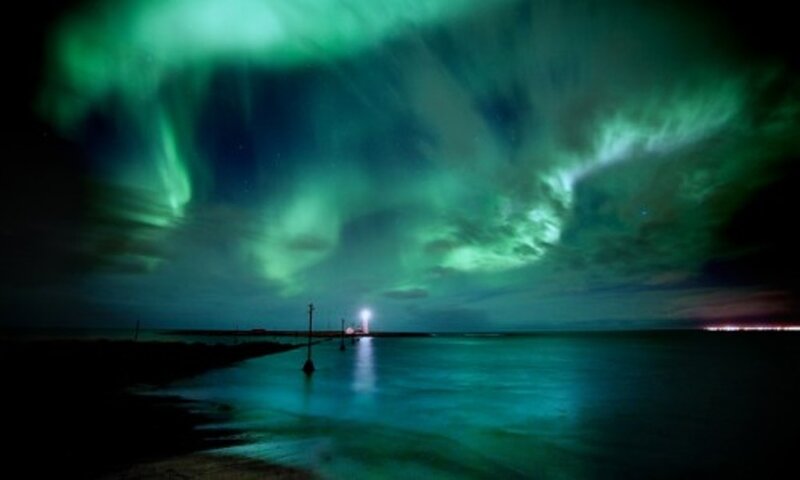 Aurora borealis over a lighthouse