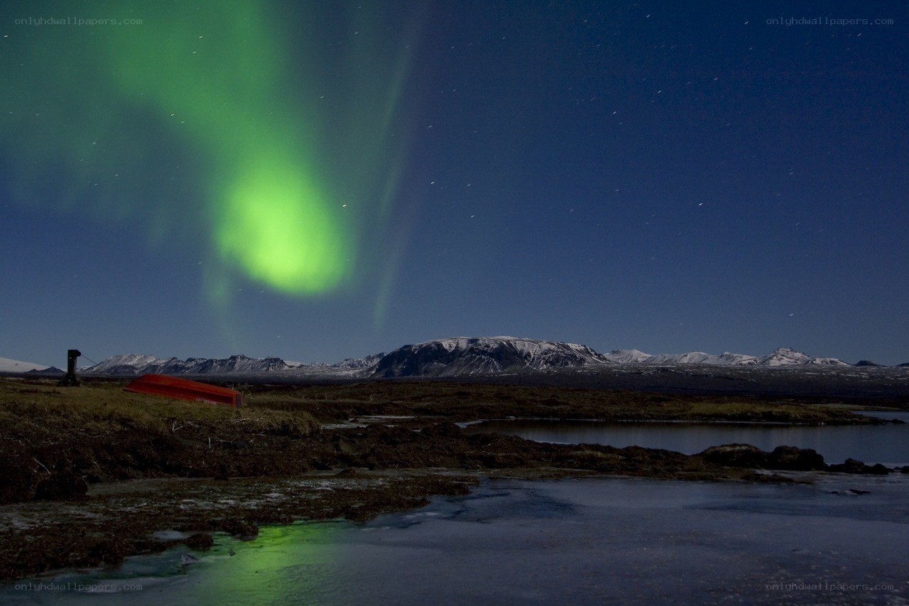 Aurora borealis over a red boat