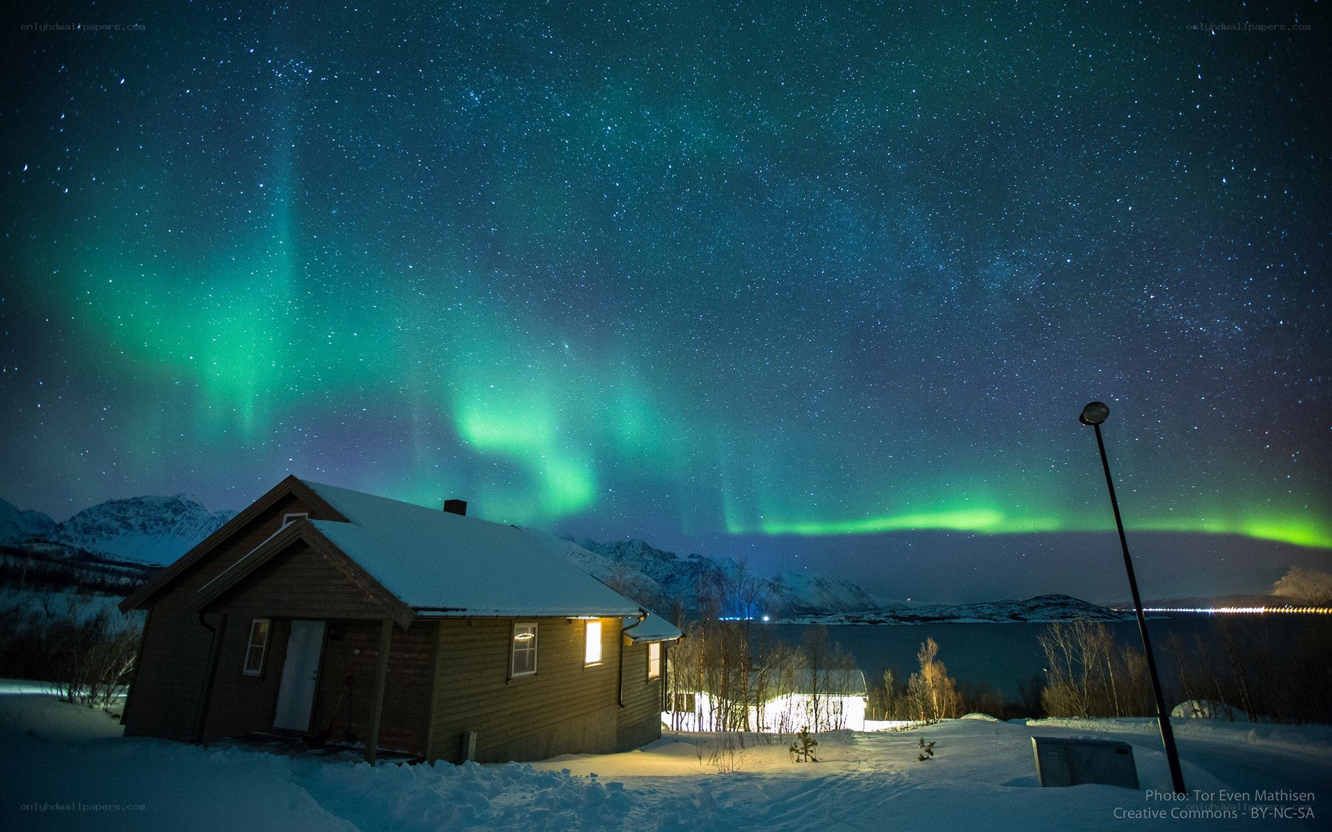 Aurora borealis over a snowy cabin