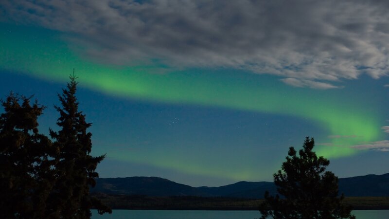 Aurora Borealis over Lake — Green, Serene, Night, Photograph, Trees, Mountains