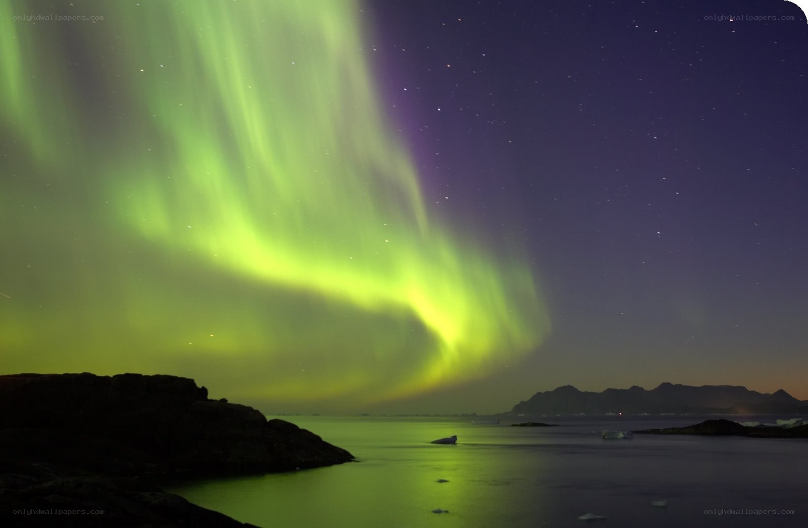 Aurora borealis over rocky coast