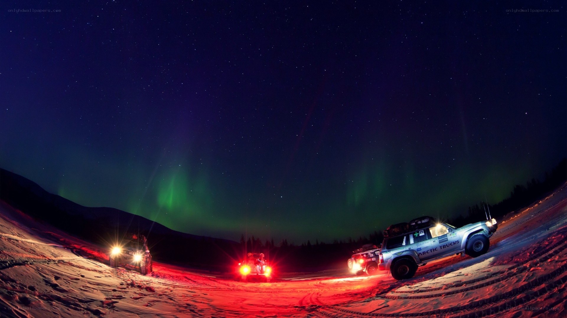 Aurora borealis over snowmobiles