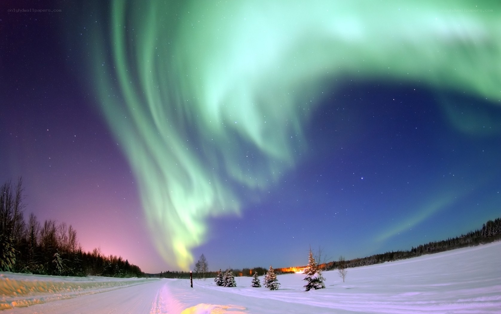Aurora borealis over snowy landscape