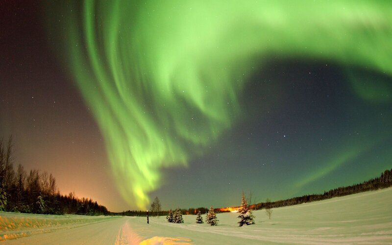 Aurora borealis over snowy landscape