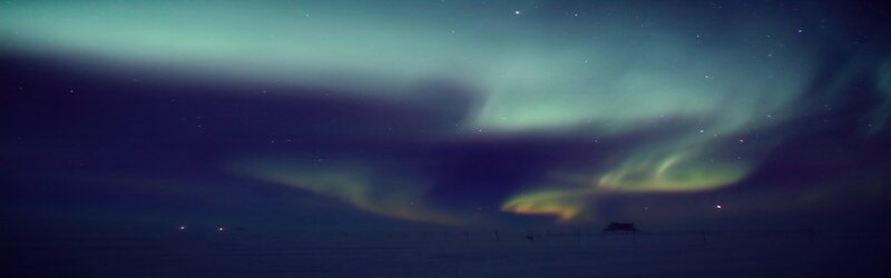 Aurora borealis over snowy landscape
