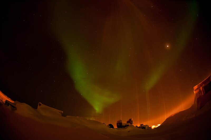 Aurora borealis over snowy landscape