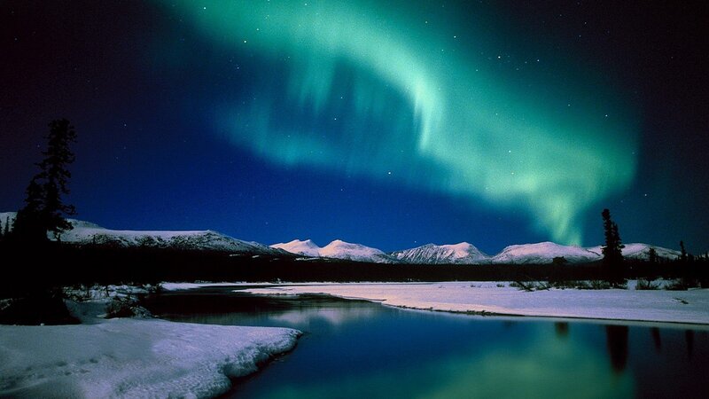 Aurora borealis over snowy landscape