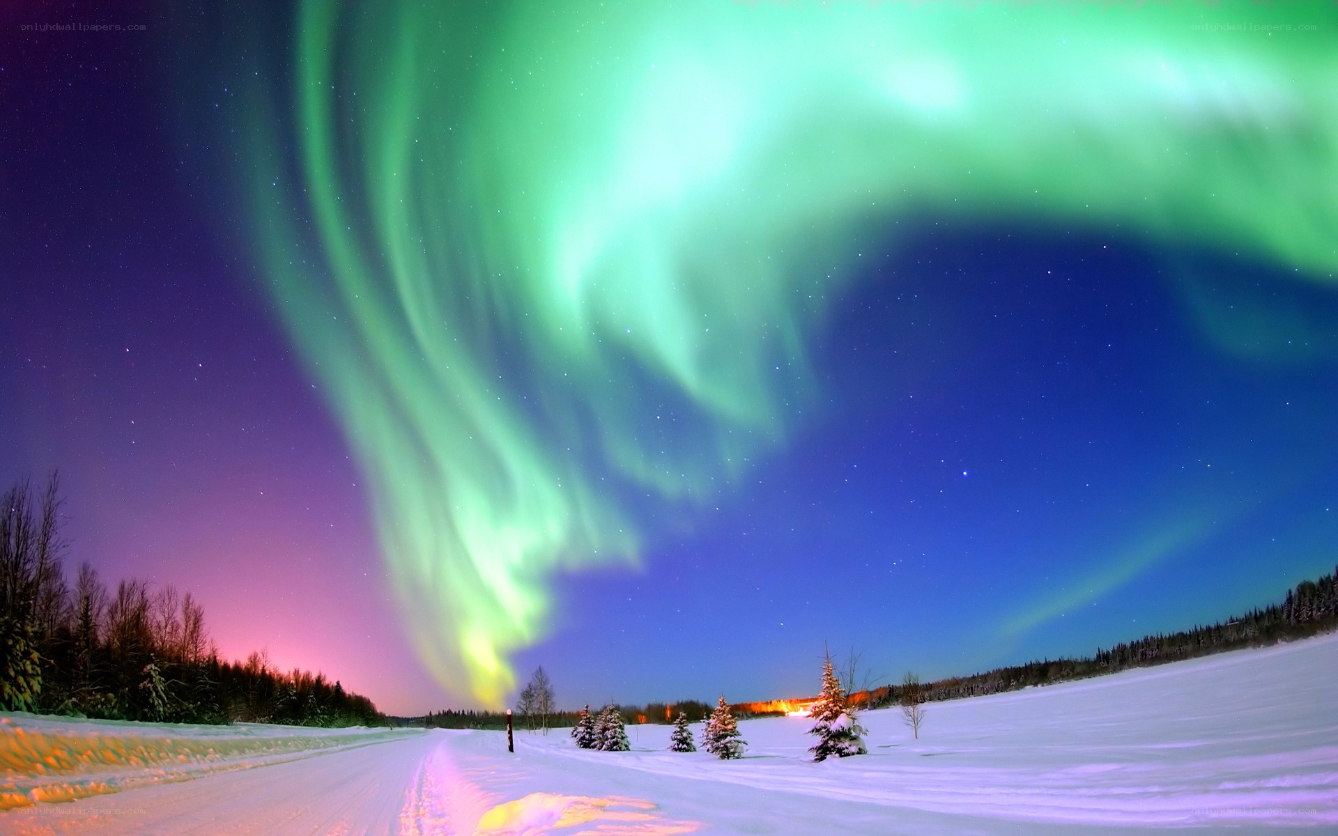 Aurora borealis over snowy landscape