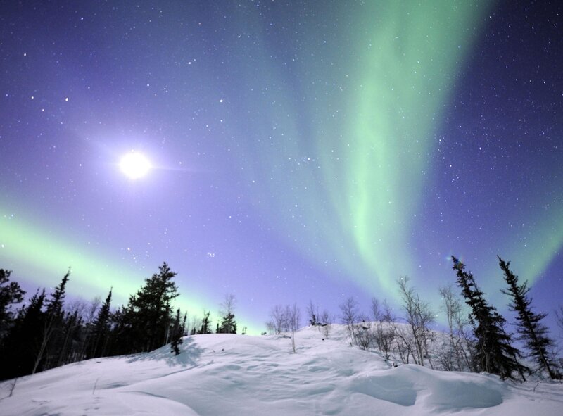Aurora borealis over snowy landscape