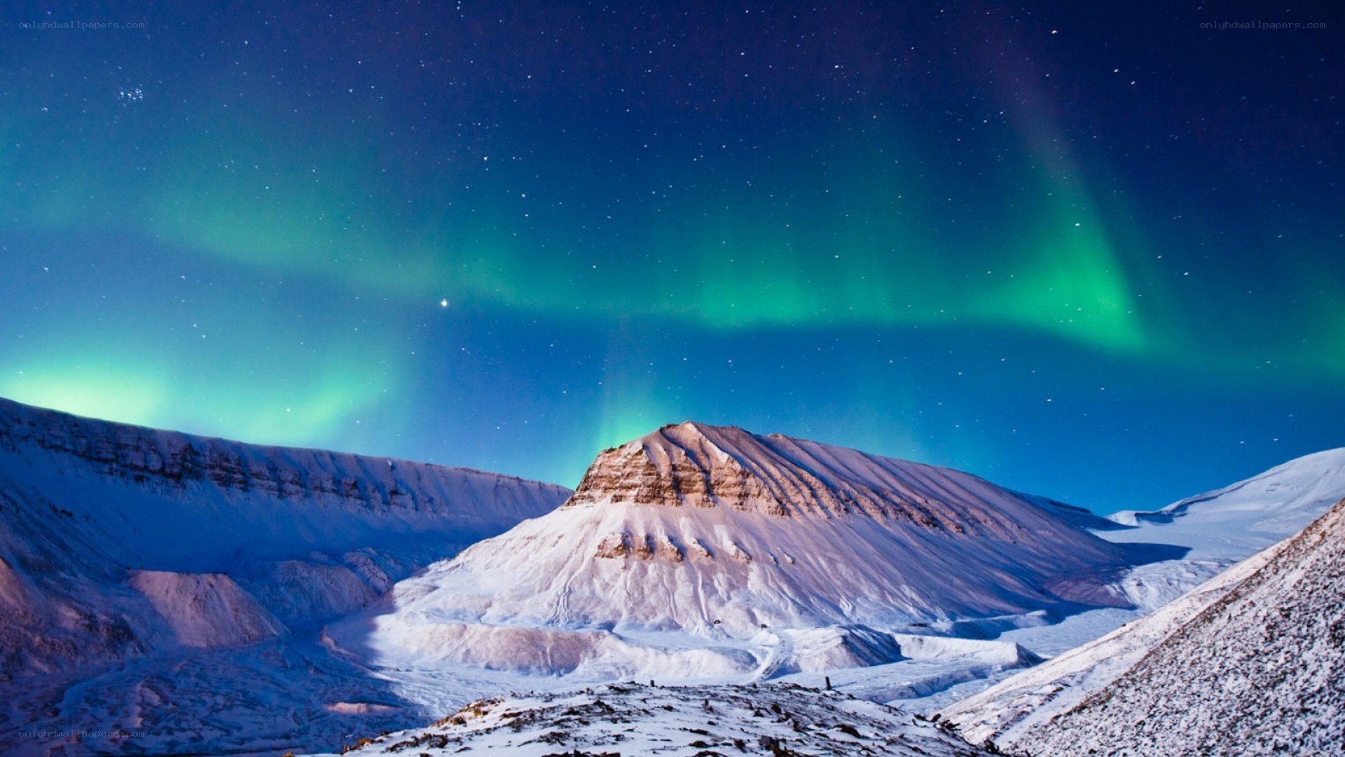 Aurora borealis over snowy mountains