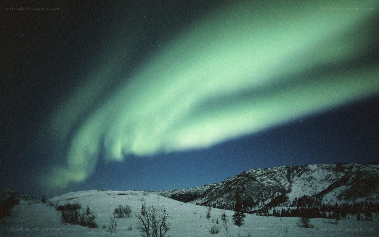 Aurora borealis over snowy mountains