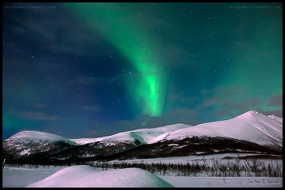 Aurora borealis over snowy mountains