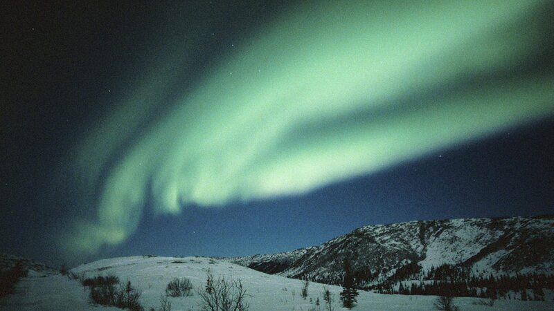 Aurora borealis over snowy mountains