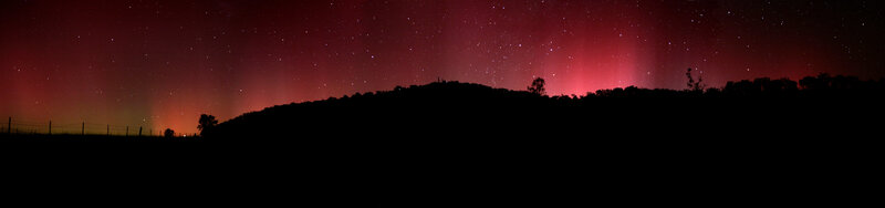 Aurora over a silhouetted hill