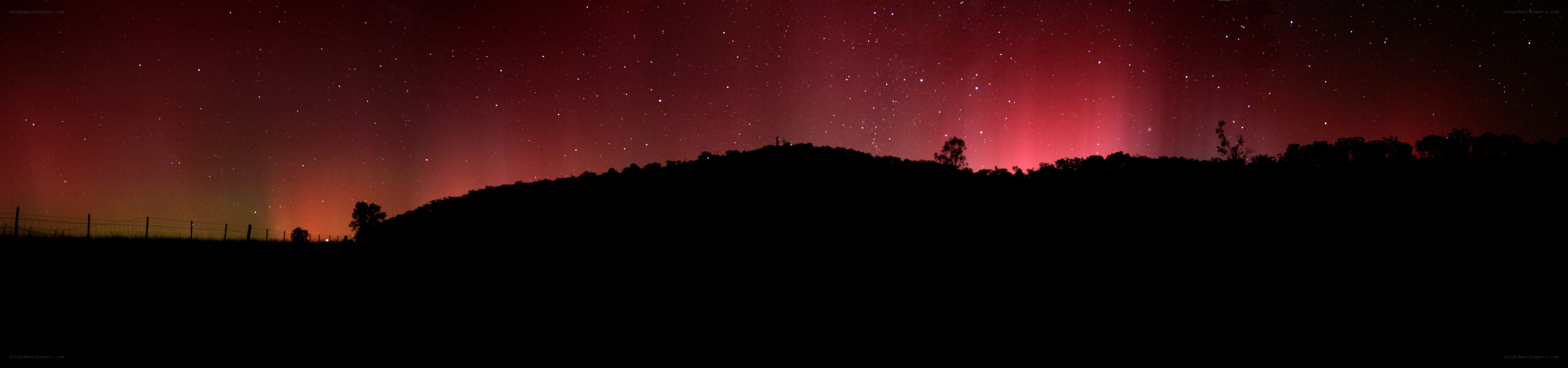 Aurora over a silhouetted hill