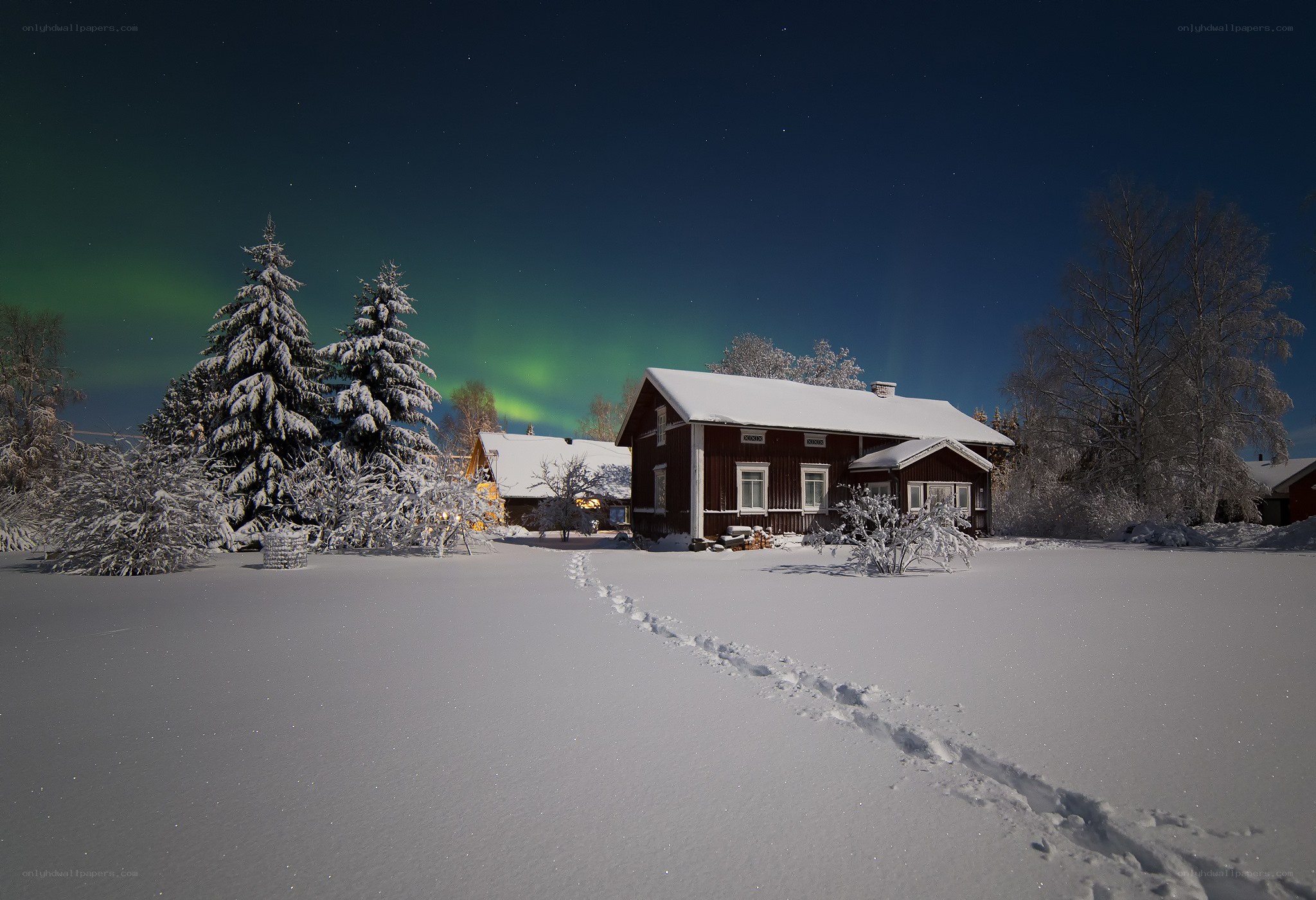 Aurora over a snowy cabin