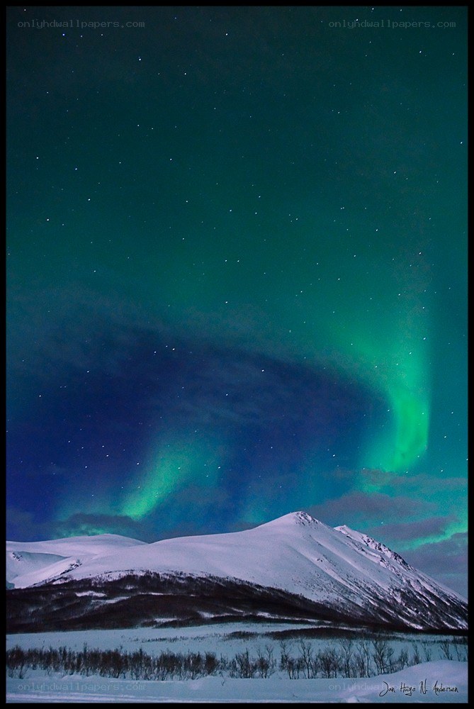 Aurora over snow-covered mountains
