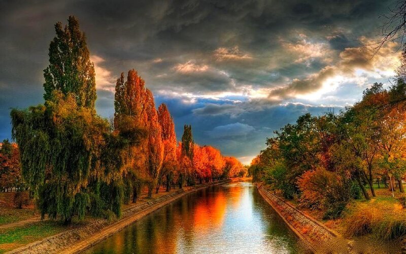 Autumn canal under dramatic sky