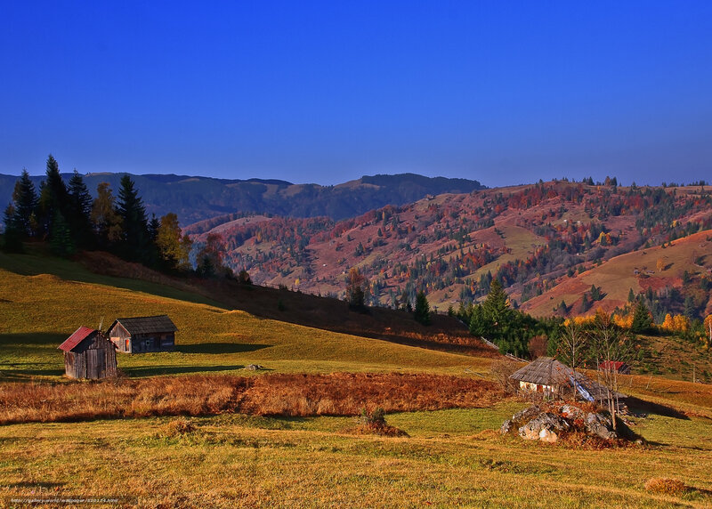 Autumn hills with wooden huts
