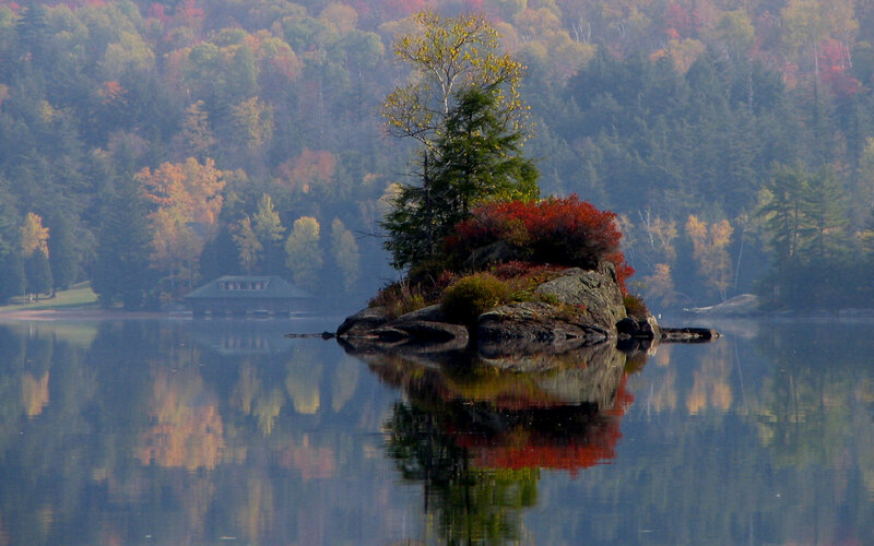 Autumn island in calm lake