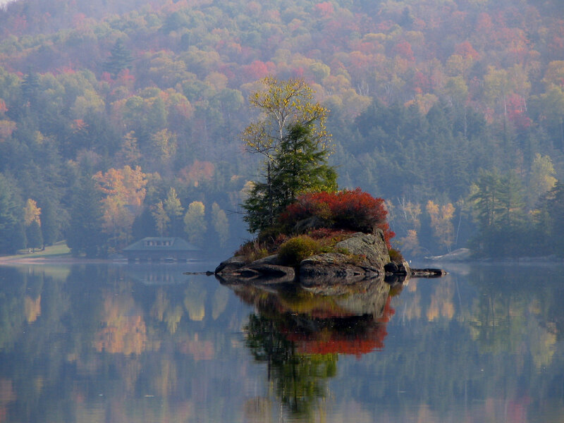 Autumn island in misty lake