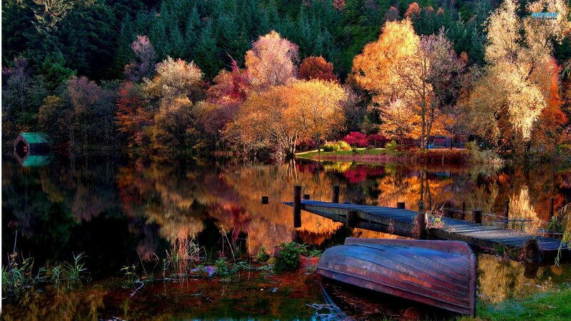 Autumn lake with boat and dock