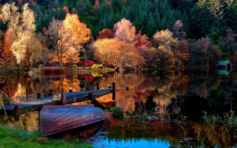 Autumn lake with boat and dock
