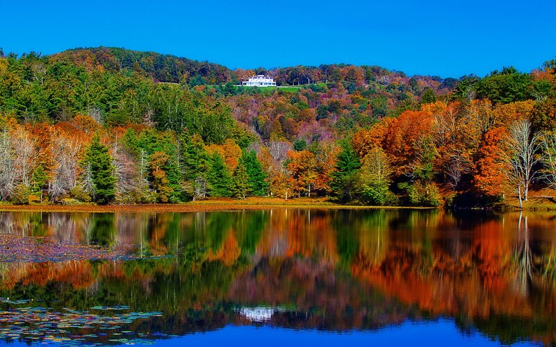 Autumn lake with house on hill