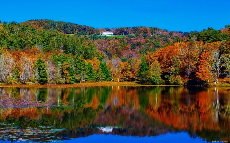 Autumn lake with house on hill