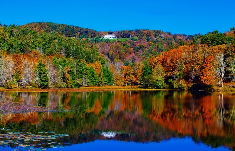 Autumn lake with house on hill