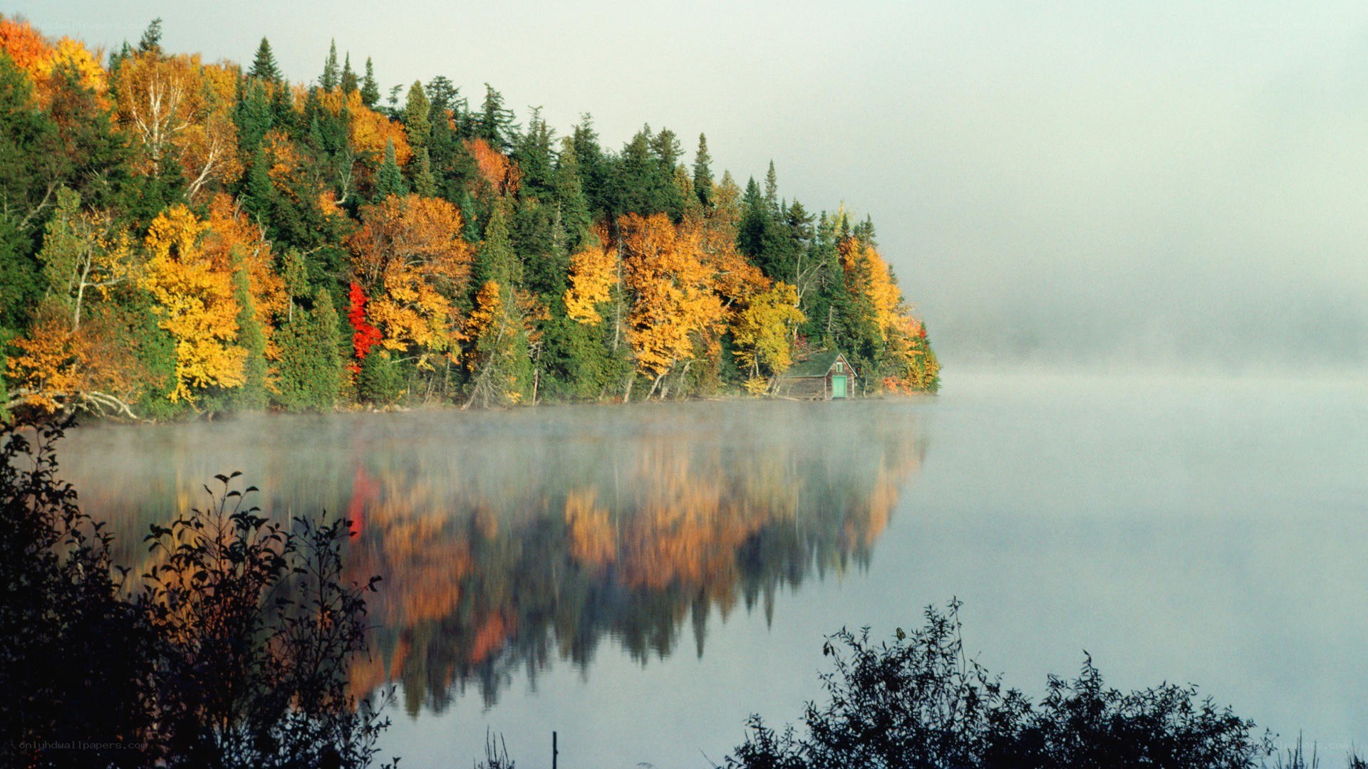 Autumn lake with misty reflection