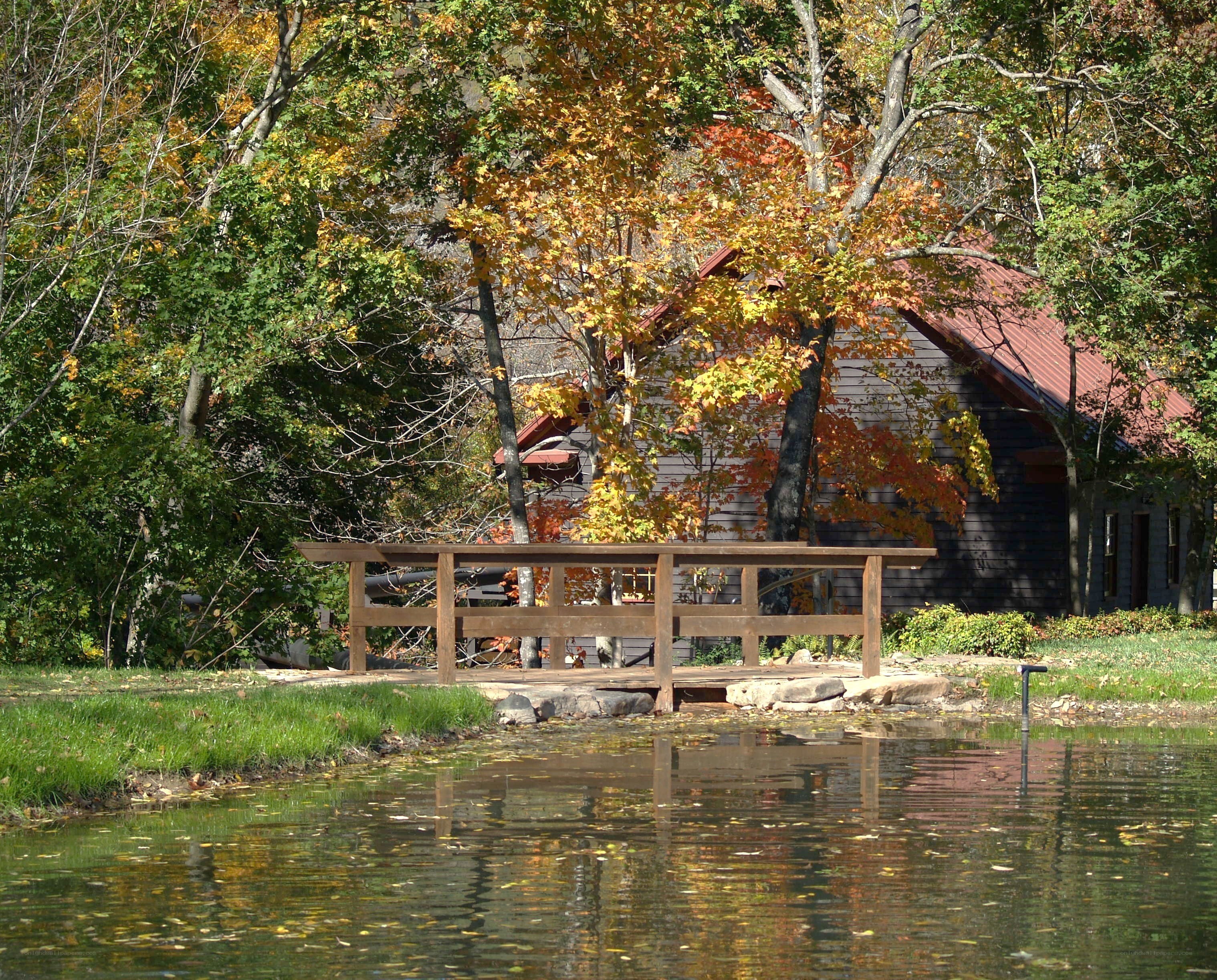 Autumn pond with wooden bridge