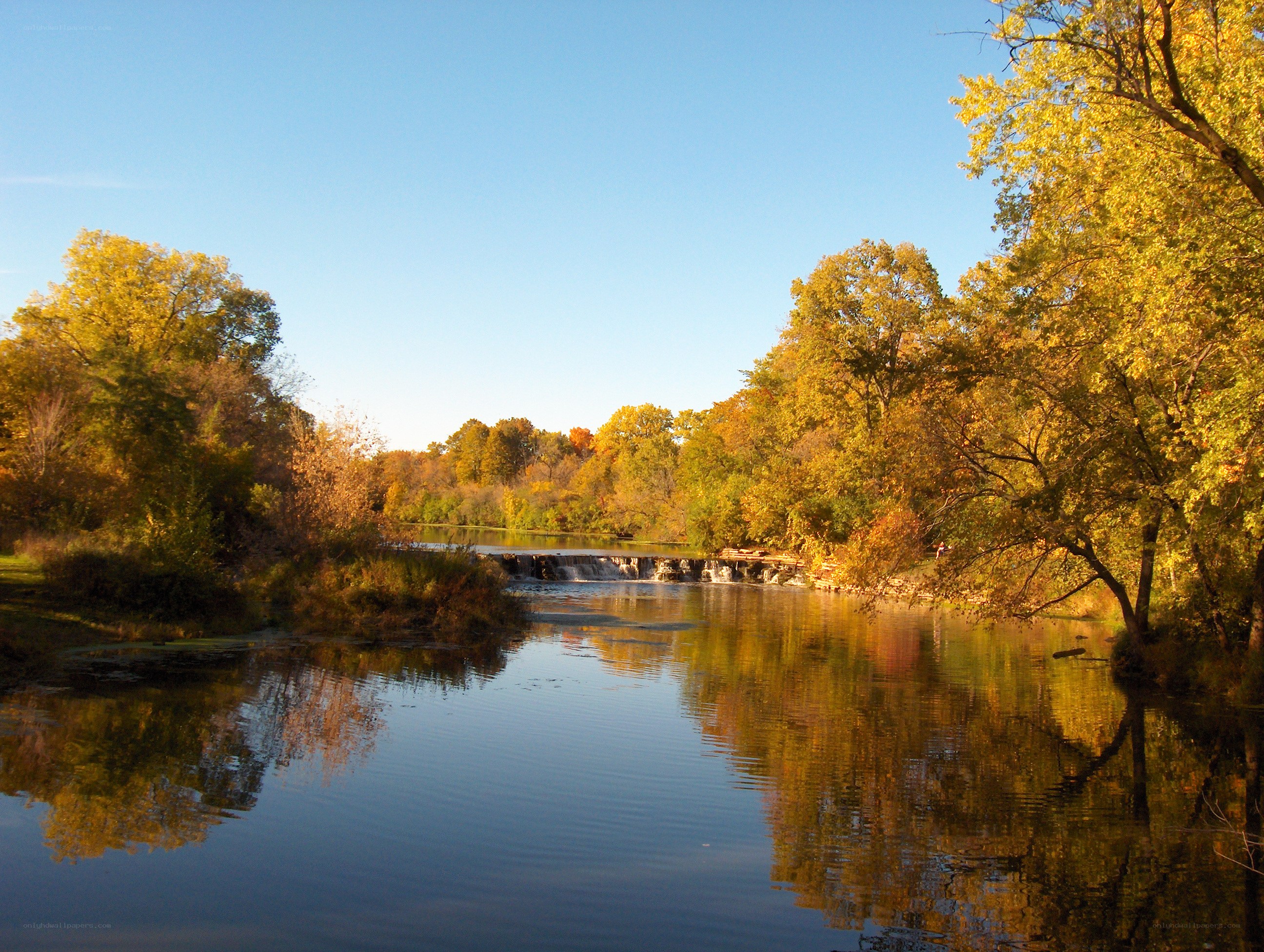 Autumn river with waterfall