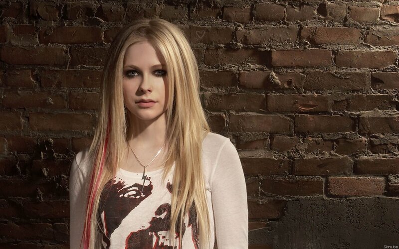 Avril Lavigne against brick wall