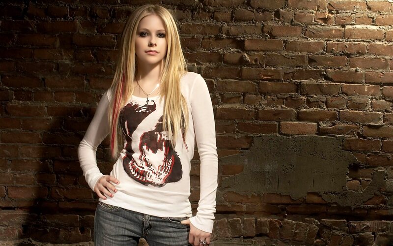 Avril Lavigne in front of brick wall