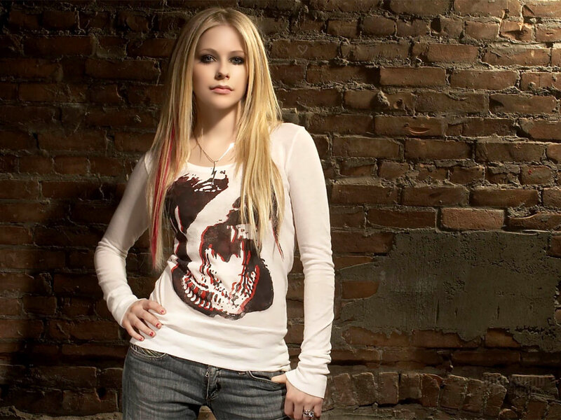 Avril Lavigne in front of brick wall