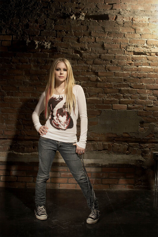 Avril Lavigne in front of brick wall