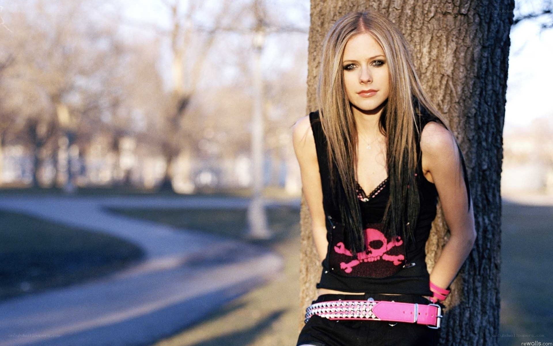 Avril Lavigne leaning on a tree