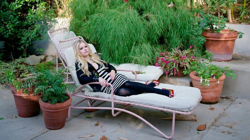 Avril Lavigne on a lounge chair