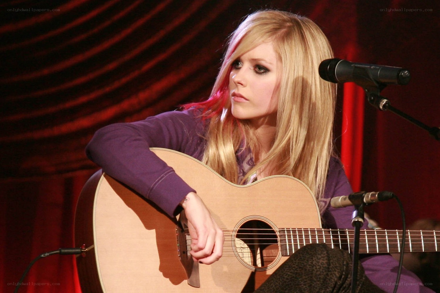 Avril Lavigne performing with guitar